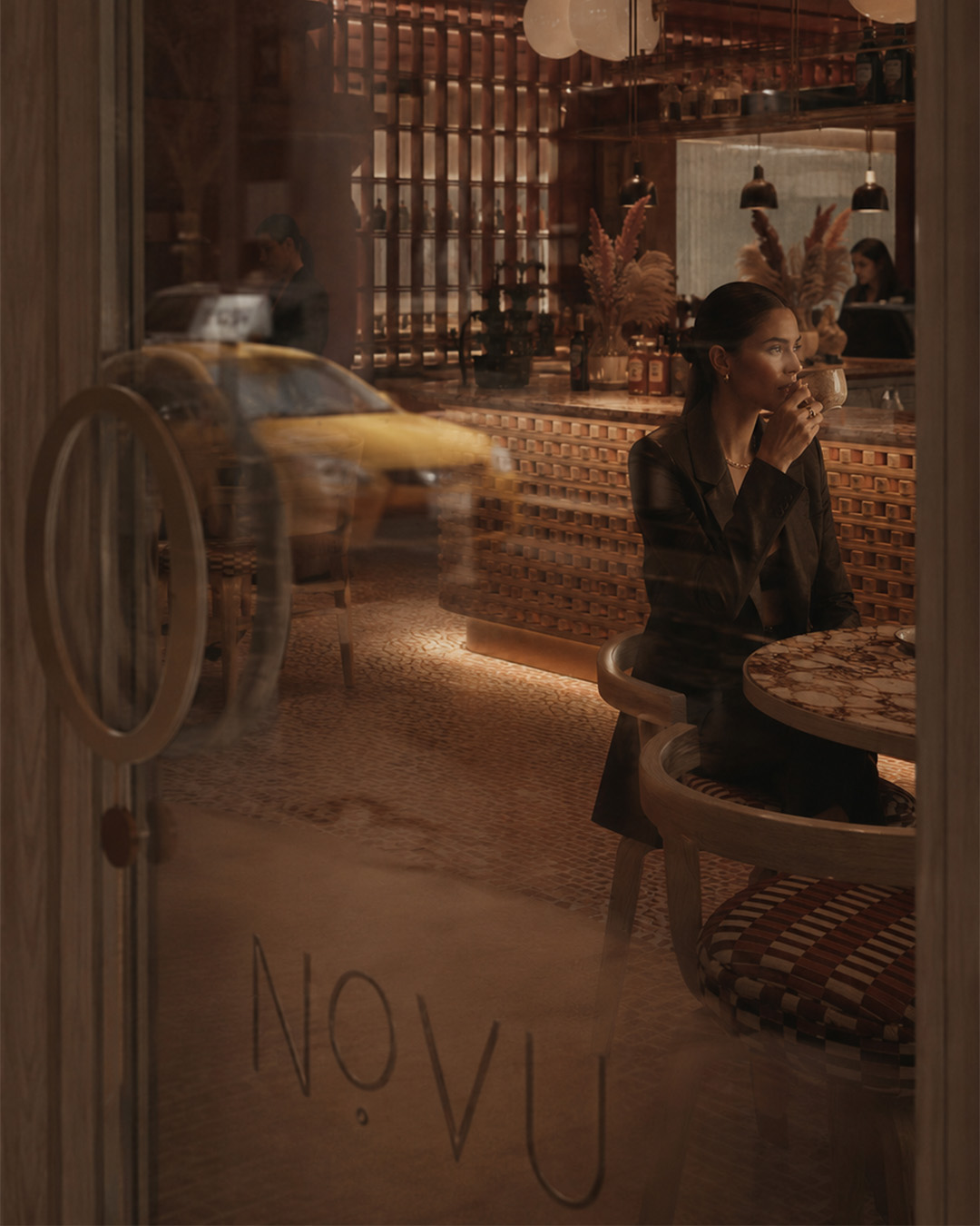 Novu Lounge Dışarıdan Mekan Logo ve Kahve içen Kadın